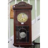A mahogany wall hanging clock with an eight-day movement