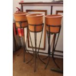 Three freestanding planters on metal stands