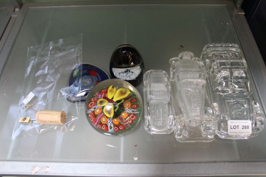 Six various glass paperweights, three being vehicular, together with two similar tie pins