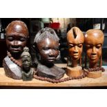 A selection of carved African Tribal heads, a good luck necklace and a candle