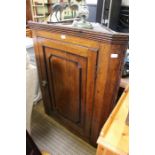 An antique oak corner cupboard