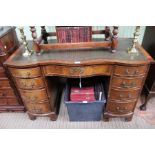 A mahogany serpentine fronted pedestal desk with insert leather top