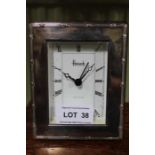 A hallmarked silver framed desk top clock bearing the legend Harrods