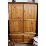 A pine wardrobe on a four drawer base