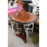 A late 19th / early 20th century mahogany oval topped table, on turned column, and tricorn plinth ba