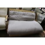 A large elephant grey futon with a wooden base by The Futon Company, with storage drawer below
