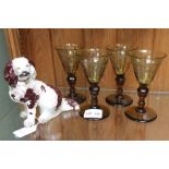 A porcelain spaniel and four etched amber drinking glass
