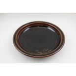 A 20th century studio pottery glazed stoneware dish with rim