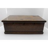 A 19th century oak box with hinged lid, the front panel reveals three lock holes (no locks), 46cm x