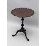 A mahogany revolving tri-pod tabel with pie crust edge top,