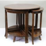 A circular oak coffee table with four nesting tables beneath, in the Art Deco style