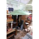 A large green finished hand crank garden parasol on patinated metal stand