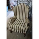 A probable 19th century wing back deep seated arm chair with Regency stripe upholstery and short sho