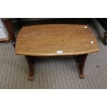 A small oak arts & crafts design coffee table on shaped plank supports, united by a pegged stretcher