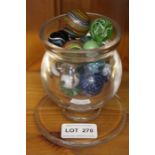 A small globular glass vessel containing marbles, various