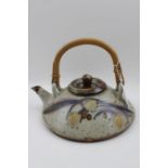 A 20th century studio pottery teapot of squat form, with bamboo handle
