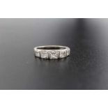 An 18ct white gold ring set five graduated square cut diamonds