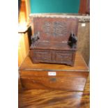 A 19th century writing slope containing old pens together with a miniature carved monks bench