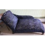 A small chaise longue, having black fabric upholstery
