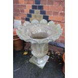 A large concrete scalloped lotus pedestal planter