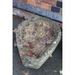 An old well weathered Cotswold stone trough, containing succulents