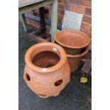 Two terracotta cylindrical planters, together with a strawberry pot