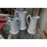 A trio of relief moulded jugs