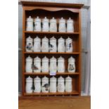 A pine finish hanging rack containing 30 Lesley Anne Ivory's spice jars decorated with cats