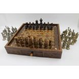 A Middle Eastern inlaid chess board, the base fitted two drawers, 32cm square,