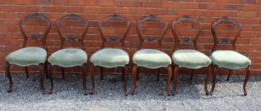 A set of six walnut French design dining chairs with carved crest rail