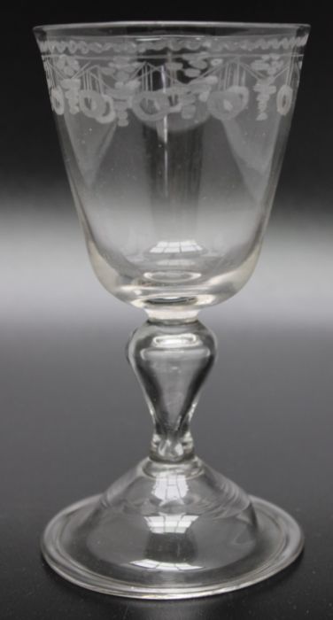 An early 18th century hollow stem wine glass, acid etched decoration circa 1750