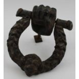 A Victorian cast iron door knocker in the form of a wreath with lion mask, held in a clenched fist,