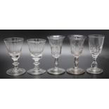 A collection of five dram glasses to include an 18th century engraved bucket bowl, an 18th century f