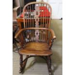 A 19th century slat & stick back rocking armchair, with solid elm seat