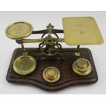 A late Victorian set of brass postal scales, on polished wood base, the plate engraved with postal r