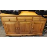 A modern pine sideboard, with the inline drawers over three cupboard doors