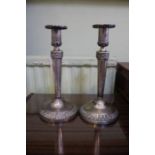 A pair of Continental silver coloured metal candlesticks in the Biedermeier design