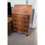 A small serpentine fronted reproduction walnut bureau