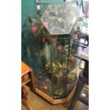 A large freestanding leaded terrarium containing an everlasting pink rose