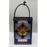 An Edwardian multi-coloured stained glass lantern within a metal frame, 30cm high