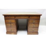 A late Victorian oak twin pedestal desk with inset skiver top over three inline drawers upon two thr