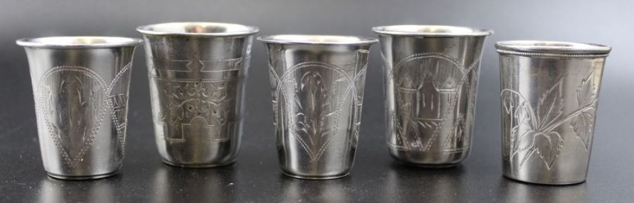 Five Russian silver vodka beakers with engraved decoration, marked 84, two dated 1870-1894