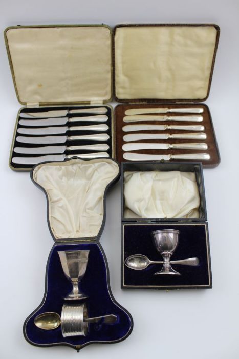 Two cased sets of egg cups with spoons, and two cased sets of silver handled knives