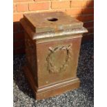 A small ceramic garden urn plinth carrying a barley twist insignia, 43cm