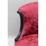 A late Victorian ebonised framed salon chair, patterned crimson fabric upholstery