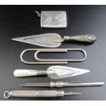 Two silver trowel bookmarks, silver stamp case, silver paper clip, and two silver toothpicks