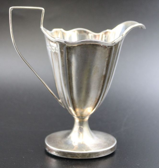 Thomas Bradbury & Sons, a late 19th century silver cream jug of tapering fluted form, weighted oval