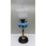 A late Victorian oil lamp, blue glass reservoir with pine cone decoration,