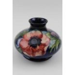 An early 20th century Moorcroft vase tube lined and painted on a cobalt blue grown Anemone pattern,