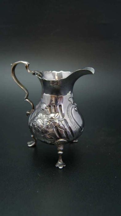 John Muns, a George III silver cream jug, embossed floral decoration, raised on three trefid support - Image 3 of 4